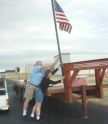 Roger Tener and Carol Doms raise the flag